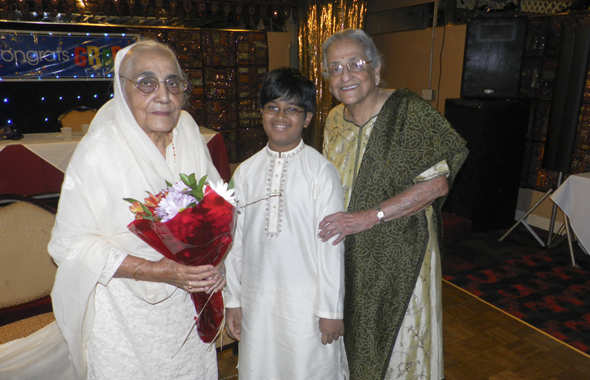 Shakuntla Malhotra (left) and Radha Golikeri pose with Adarsh Suresh, who sang the national anthems.