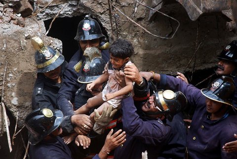 Rescue personnel pulled out a girl who was trapped under the debris of a collapsed residential building in Mumbai, Maharashtra, on Friday.