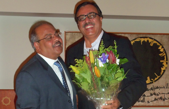 Hussain presenting a bouquet to Jamatkhana President Aftab Ghesani.