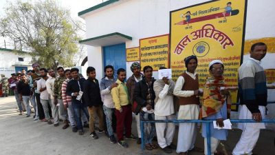 Men wait in a queue to cast their votes at a polling station in Muzaffarnagar in Uttar Pradesh on Saturday.(AFP)
