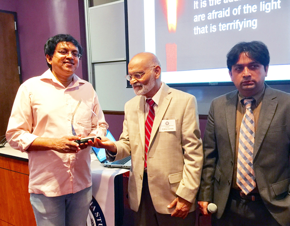 Rationalist campaigner Babu Gogineni (left) receives an award from Foundation for India Studies Chairman Krishna Vavilala (center) with event emcee Vishal Merchant.