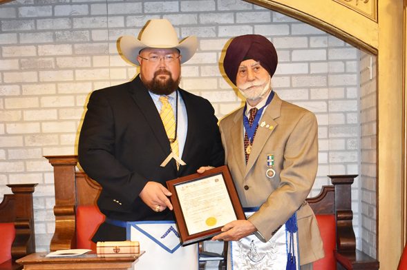 Dr. Raj Bhalla receiving his dedication award from the Worshipful Master Cody Cockroft