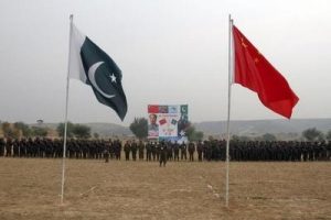 Pakistan and China's national flags fly in the foreground as soldiers from both countries stand together for a group shot after holding joint military exercises in Jhelum, located in Pakistan's Punjab province November 24, 2011. REUTERS/Faisal Mahmood  (PAKISTAN - Tags: POLITICS MILITARY)